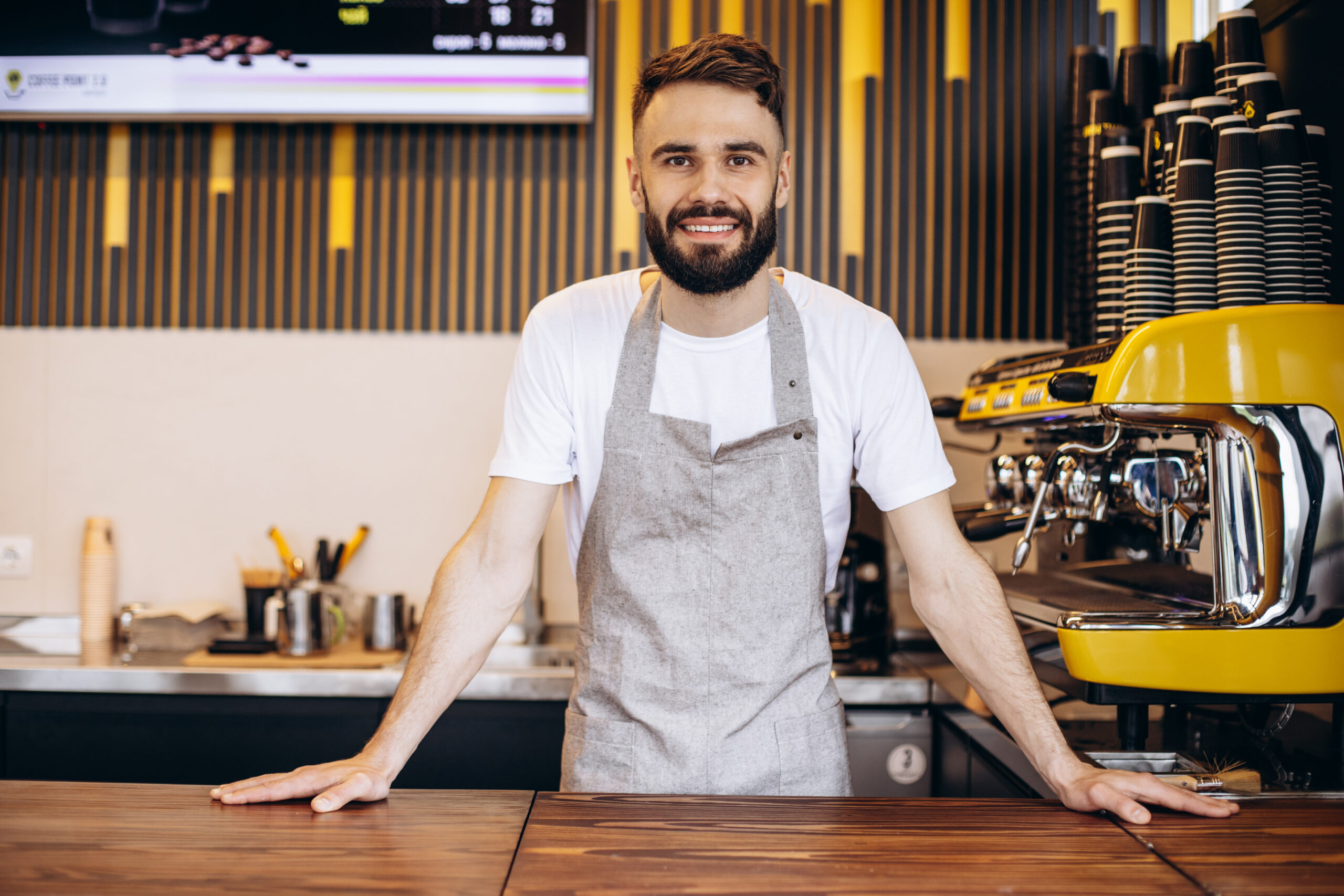 Young male barista working at a coffee house